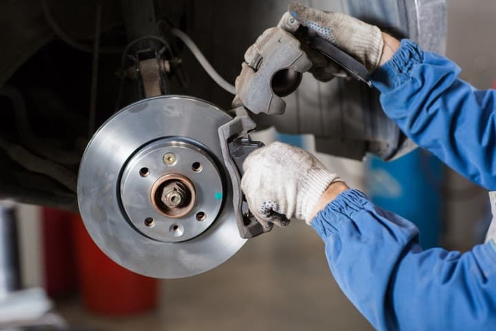 A technician servicing a car's brakes